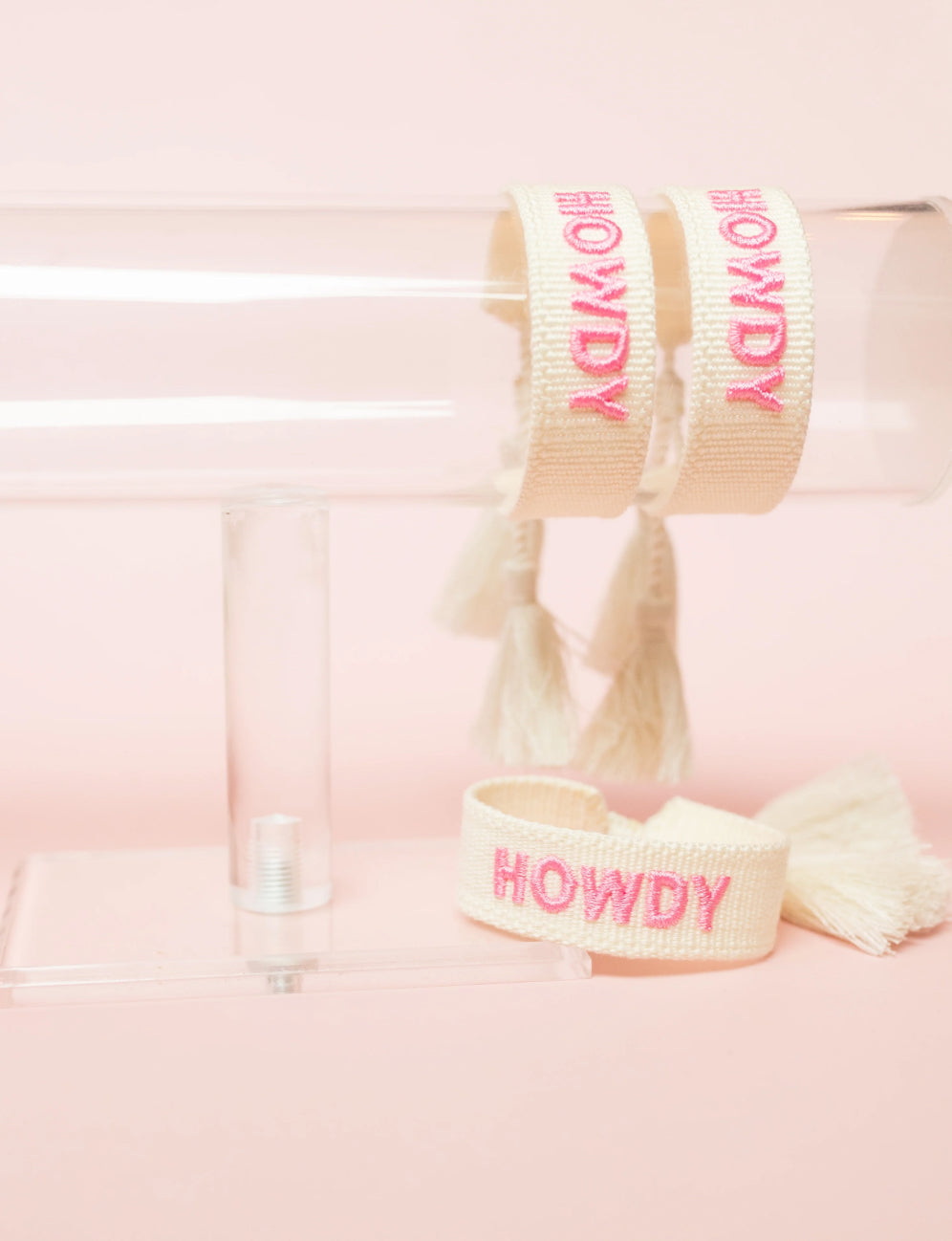 embroidered howdy bracelet on bracelet stand with pink writing and background