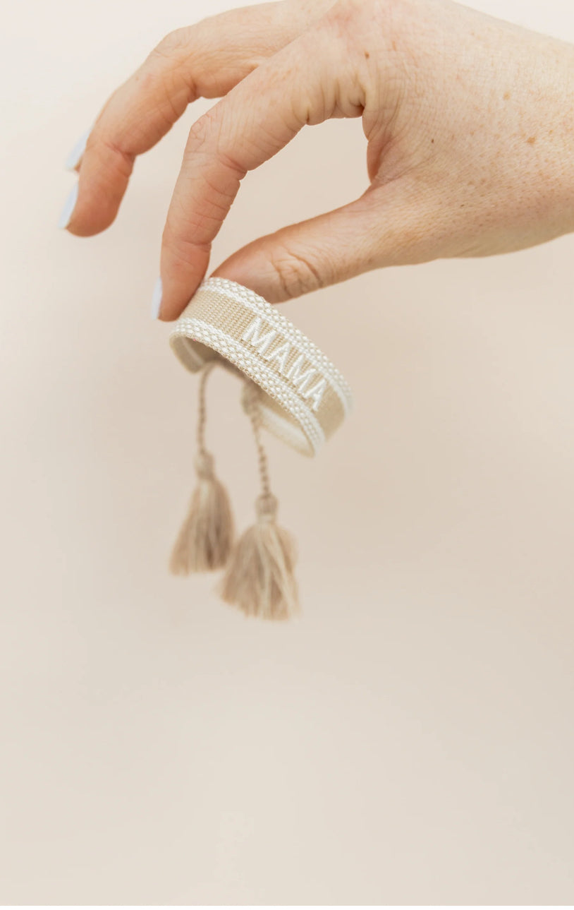 mama embroidered tan bracelet adjustable being held by fingers