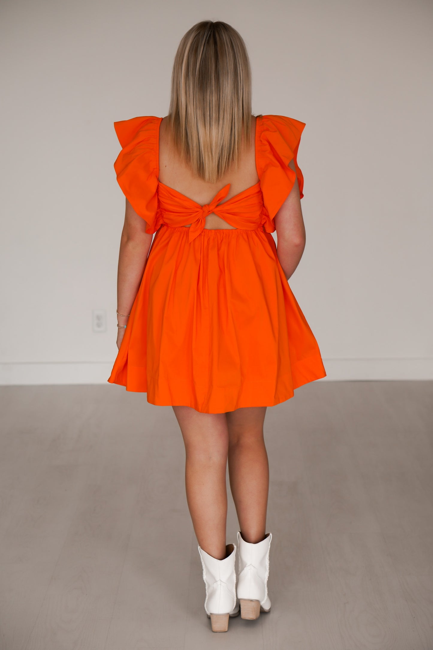 Showing off the back of the orange dress which ties in the back