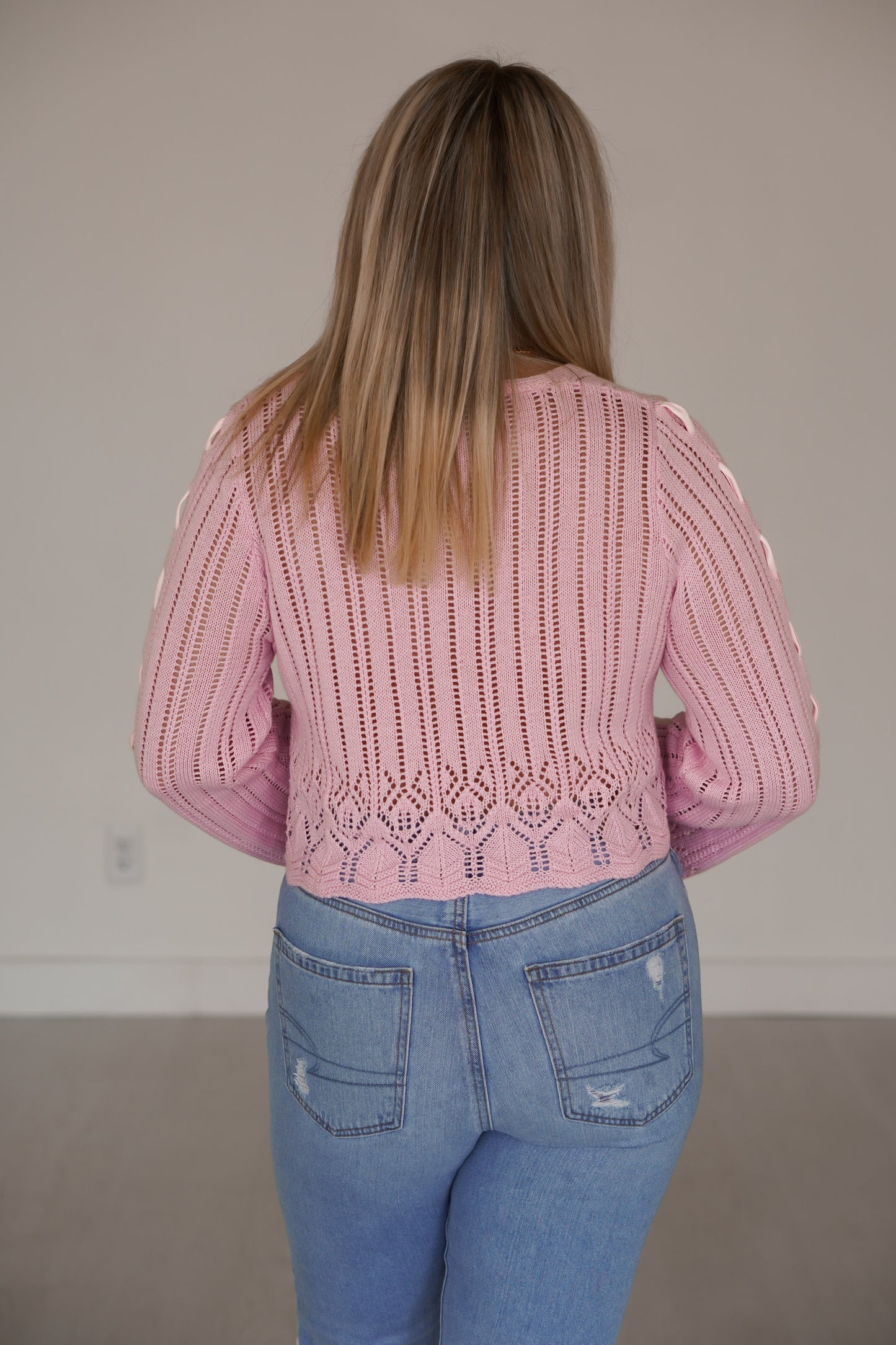 Showing off the back of the pink crocheted long sleeve shirt