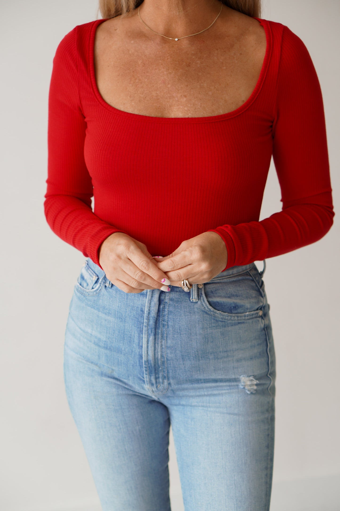 showing an up close of the neckline on the red long sleeve shirt 