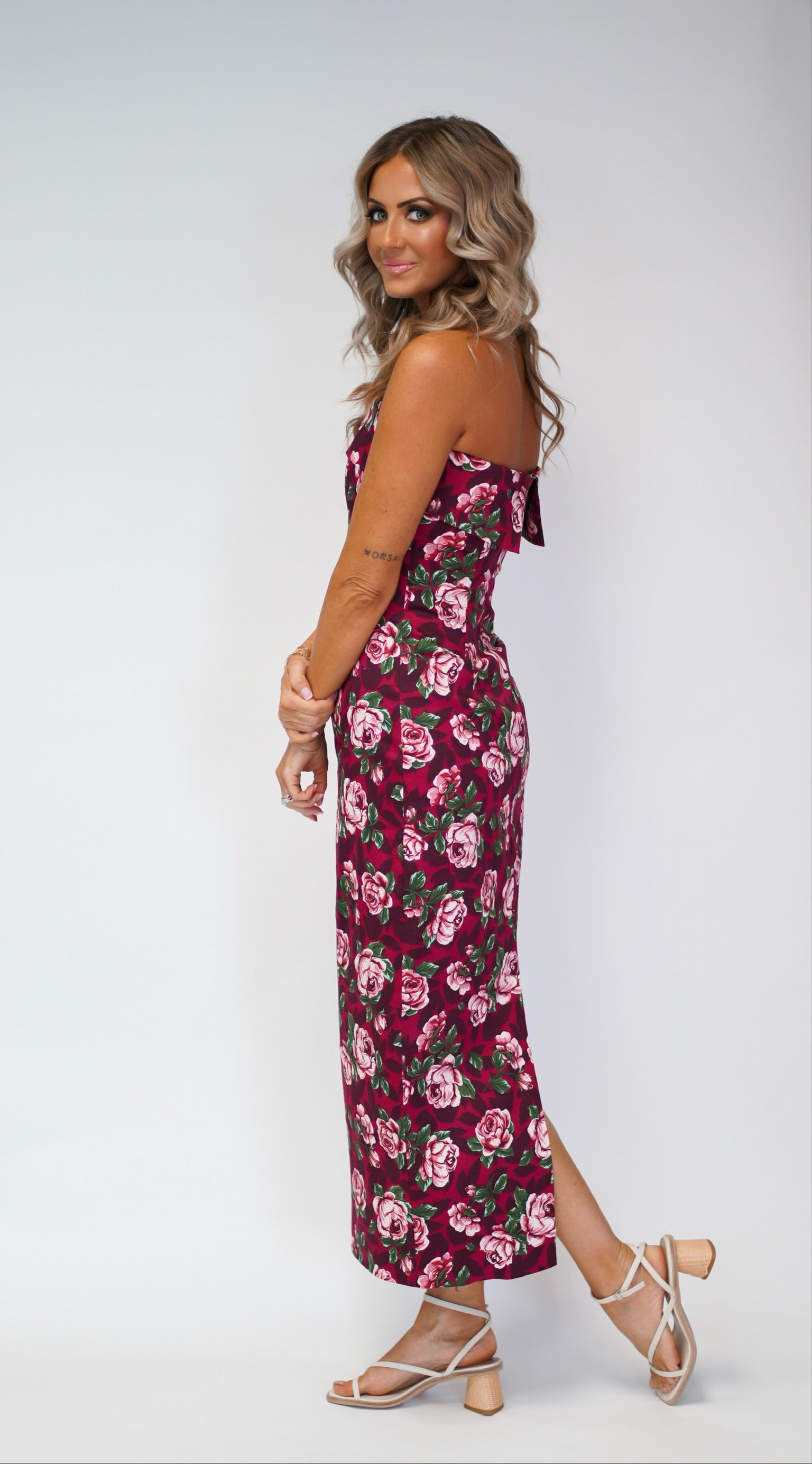 girl wearing tube dress with floral detail maxi style while the girl is standing sideways toward camera