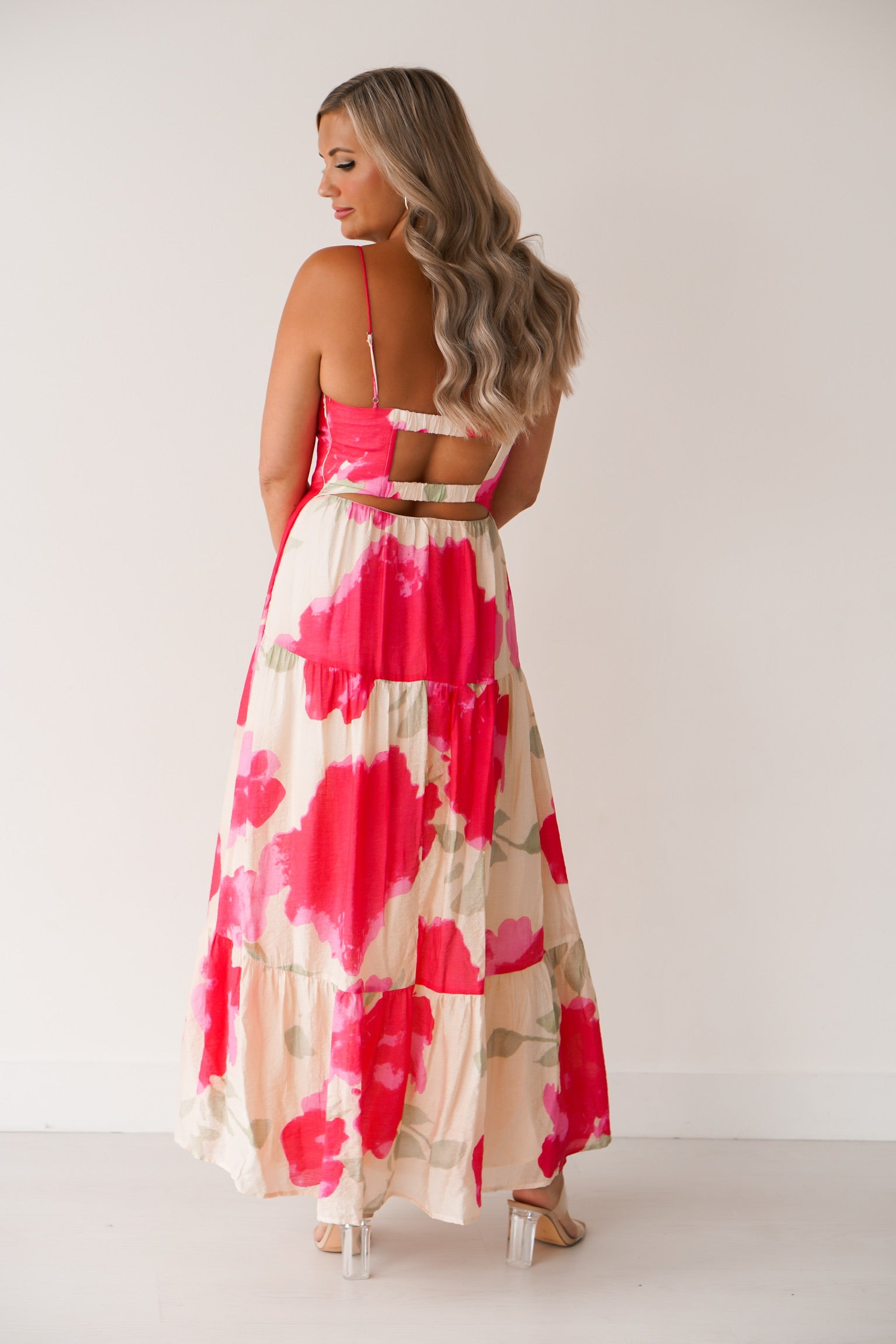 showing off the back of the pink floral dress which has a somewhat open back 