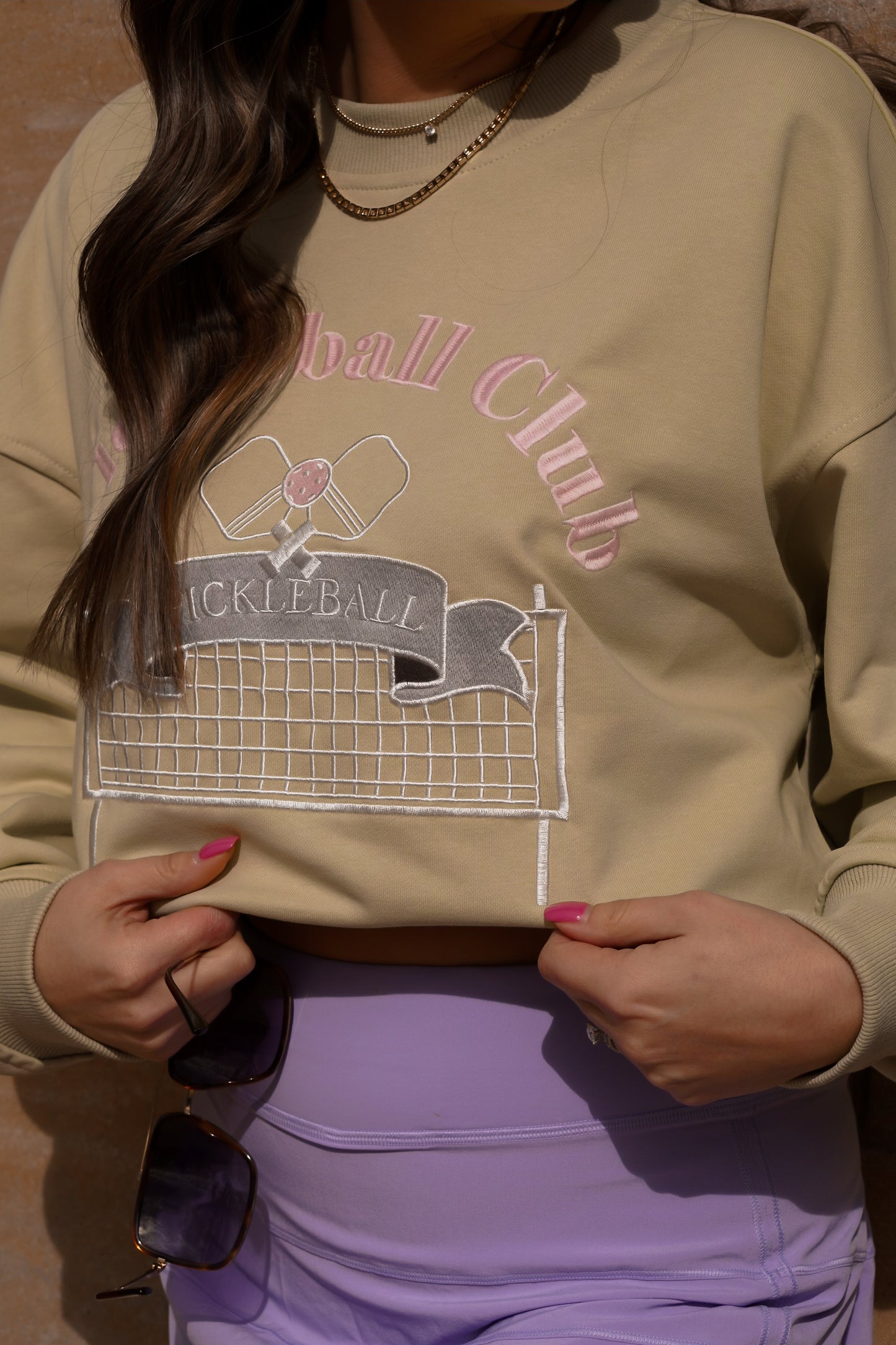 girl wearing sunglasses in our pickleball sweatshirt with tennis skirt