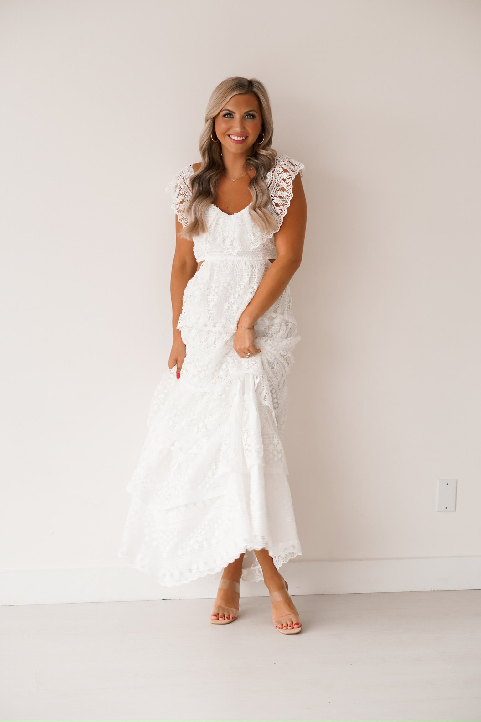 lady crossing her legs while showing off the white laced dress