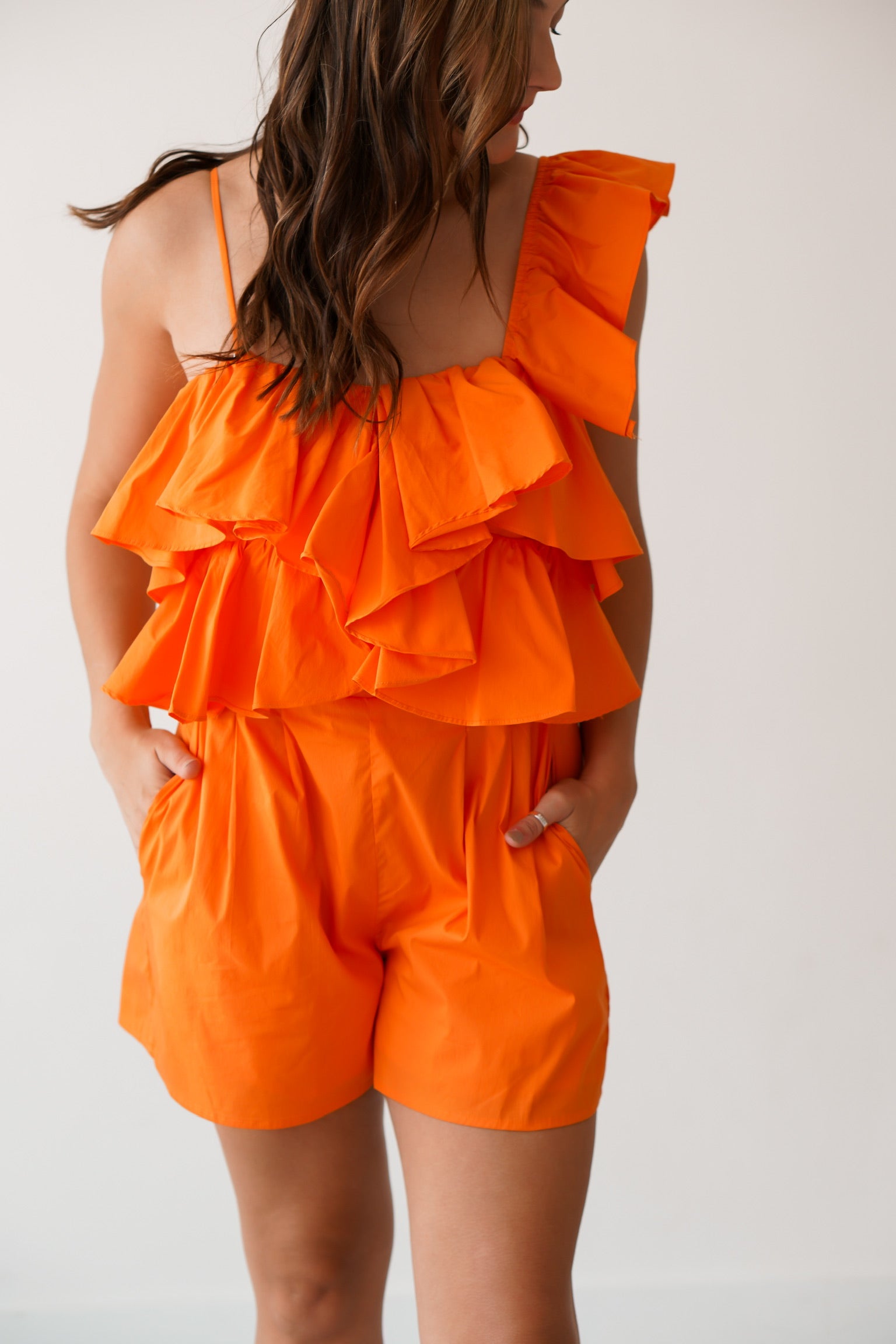 Up close of the ruffled orange one shoulder romper