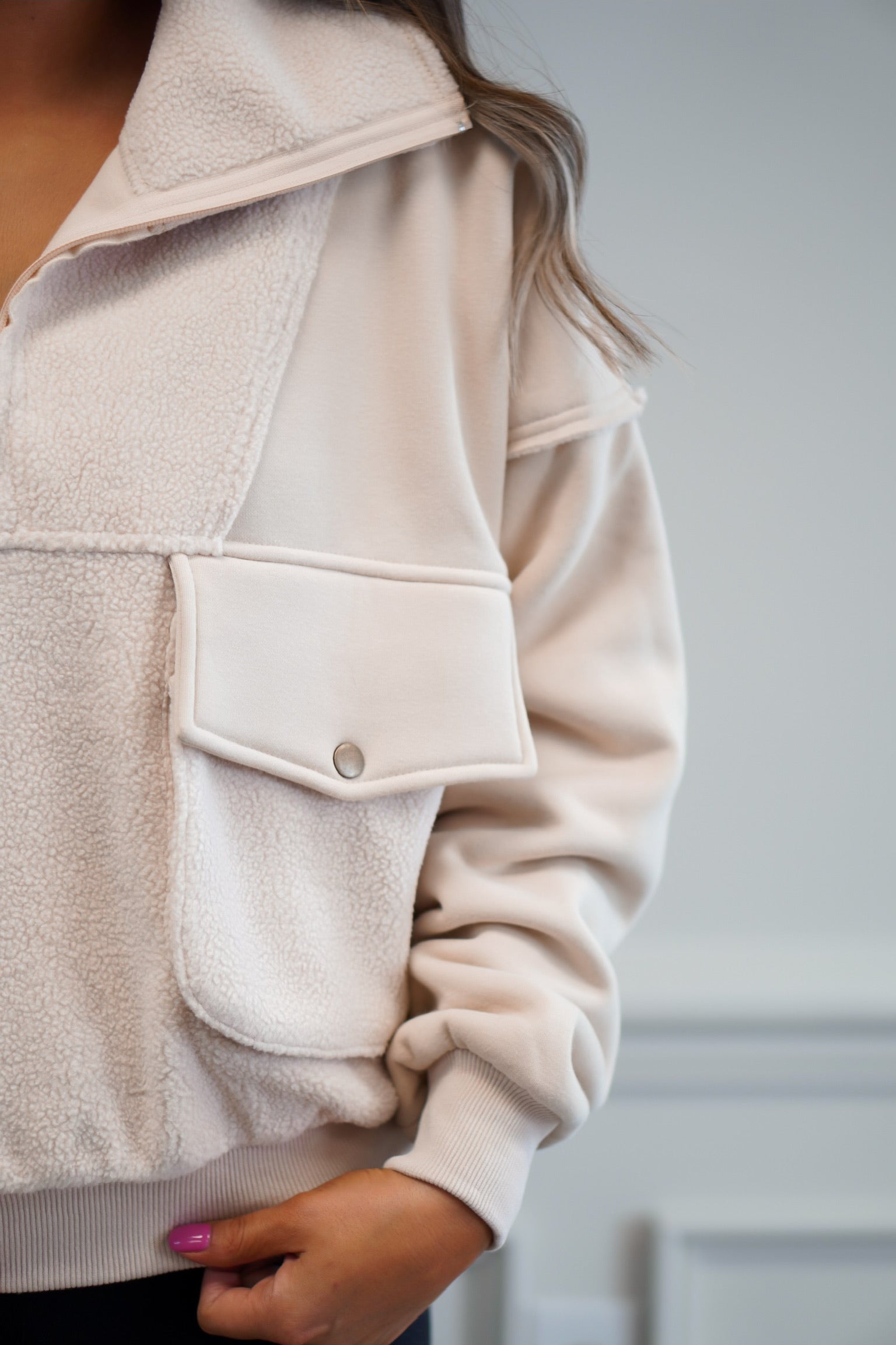 close up shot of a girlwearing a fleece pullover with cargo pockets and half zip 