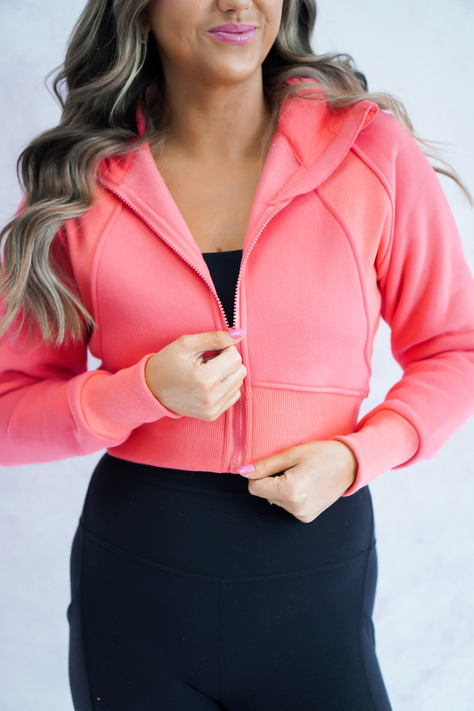 close up shot of coral cropped jacket that has an athletic/ loungewear vibe