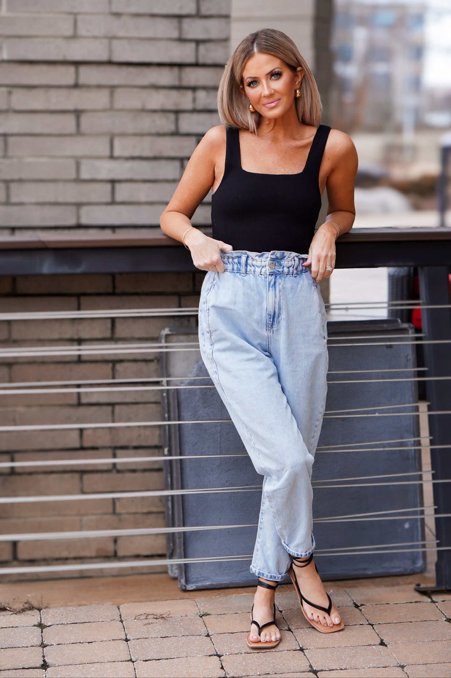 girl posing wearing black bodysuit with jeans 